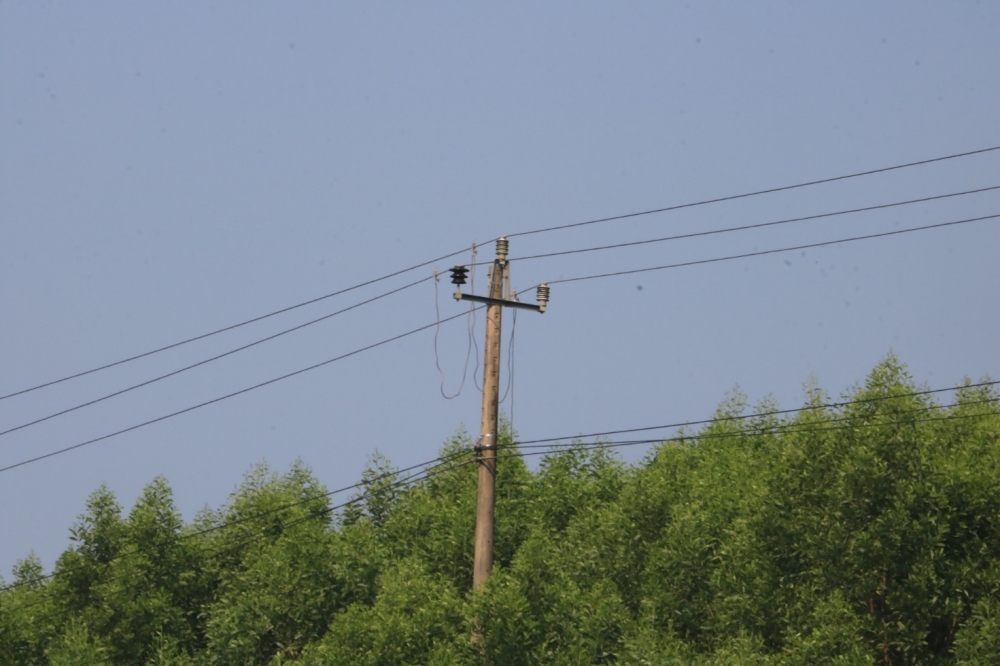 A telephone pole with power lines

Description automatically generated