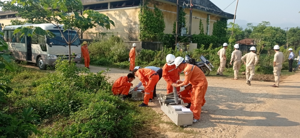 A group of people in orange jumpsuits working on a piece of metal

Description automatically generated