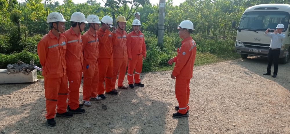 A group of people in orange jumpsuits and helmets

Description automatically generated