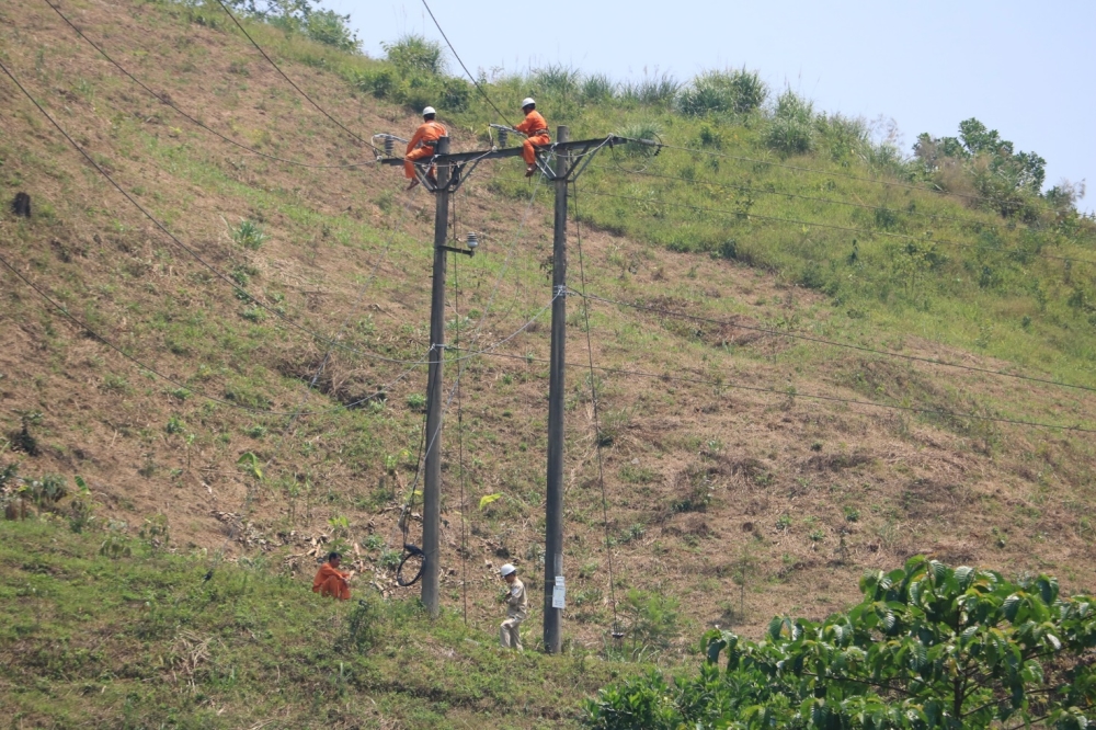 A group of people working on a power line

Description automatically generated